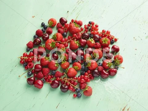 Overhead View Of Red Summer Fruits On Green Background