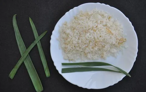 Overhead view of rice in white plate isolated over black background  Stock Photos