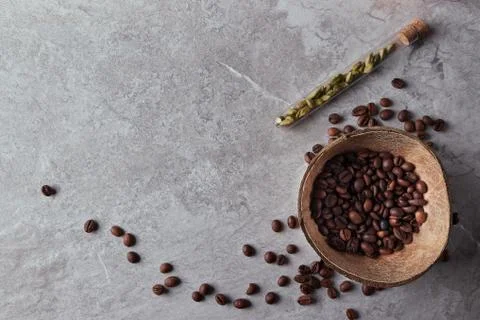 Overhead view of roasted coffee beans in coconut shell on rustic wooden backg Stock Photos