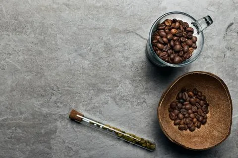 Overhead view of roasted coffee beans in coconut shell on rustic wooden backg Stock Photos
