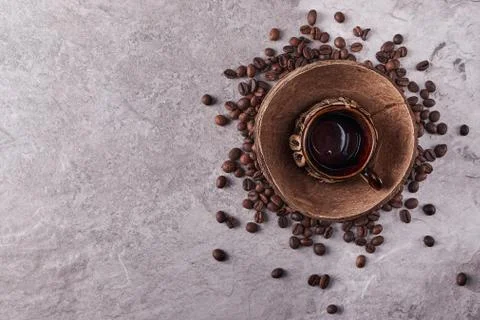Overhead view of roasted coffee beans in coconut shell on rustic wooden backg Stock Photos