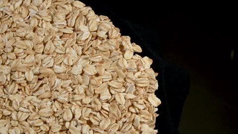 Overhead View of Rotating Rolled Oats on Black Background. 動画素材 333049113