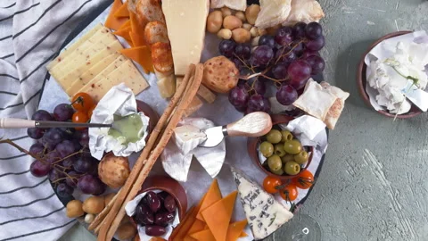 An overhead view of a round board with cheese, honey and fruit appetizers on a g Stock Footage 304458182