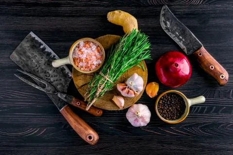 Overhead view of rustic butcher meat knife, cleaver and fork with herbs and s Stock-Fotos