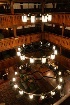 Overhead view of rustic hall with large chandelier and wooden balconies. Stock Photos
