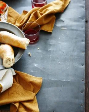 Overhead view of rustic metal table with plate of fresh bread and red wine Stock Photos