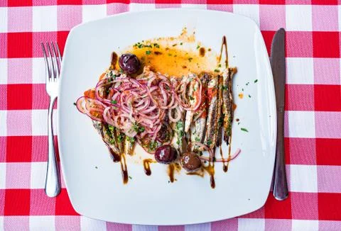 Overhead view of salted sprats marinated with red onion rings Stock Photos