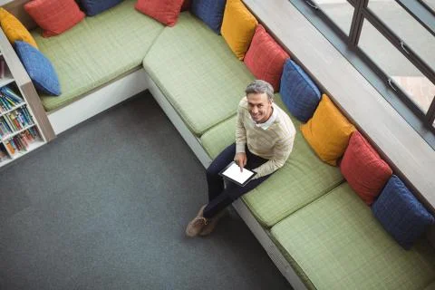 Overhead view of school teacher using digital tablet in library Stock Photos
