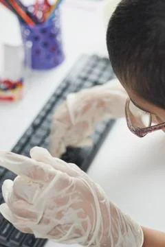 Overhead view of schoolboy typing on keyboard Stock Photos