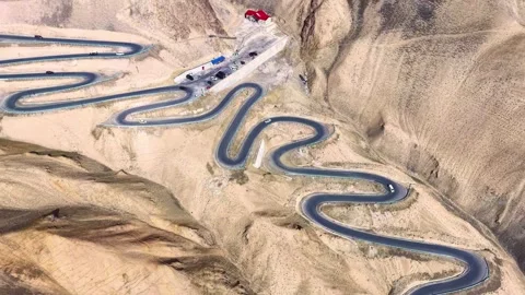Overhead View of Serpentine Mountain Road in Desolate Desert Xinjiang China Stock Footage 346572625