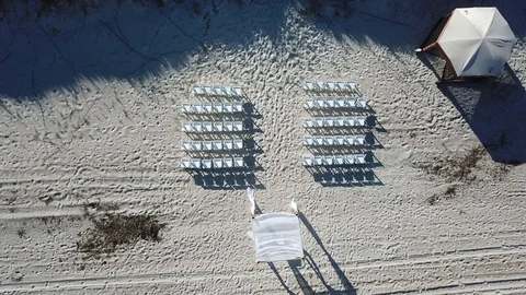 Overhead view of the set up of a wedding before it begins on the beach. Stock Footage 96469928