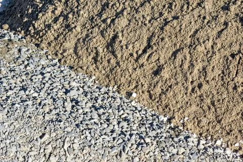 Overhead view showing diagonal boundary between crushed stone and sand for Stock Photos