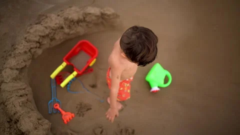 Overhead View Shows Waves Washing Into a Hole in the Sand Stock Footage 343914844