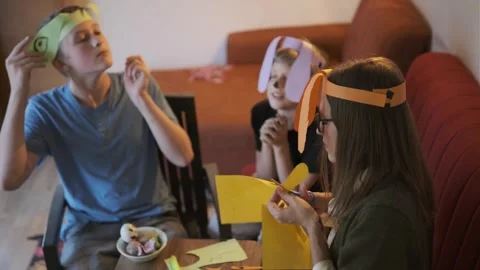 Overhead view of siblings and mother crafting Easter eggs, festive home Stock-Footage 336669133