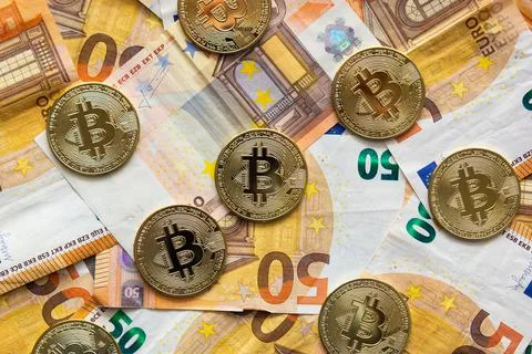 Overhead view of some bitcoins on a background of 50 euro bills. Bitcoin as n Stock Photos