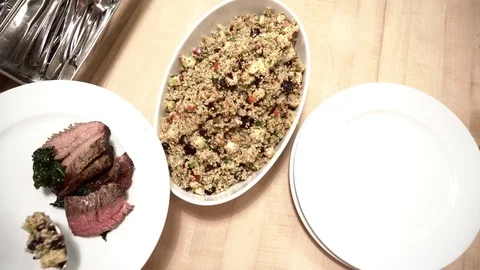 Overhead view as someone serves a quinoa salad onto a place Stock Footage 113495592