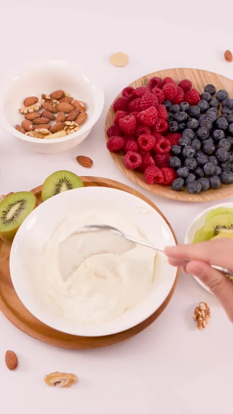 Overhead View of Spooning Thick Greek Yogurt into White Bowl Stock Footage 338054972