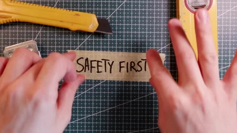 Overhead view of sticking SAFETY FIRST tape label near tools. Stock Footage 337816230