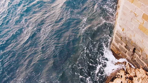 Overhead view of stormy sea, with an high wall on the side Stock Footage 142477656