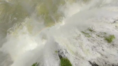 Overhead view of strong white water plunging down a cliff with green vegetation Stock Footage 327691936