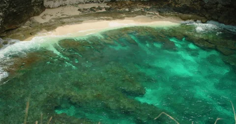 Overhead view of stunning turquoise ocean water waves washing onto narrow white Stock Footage 342464509