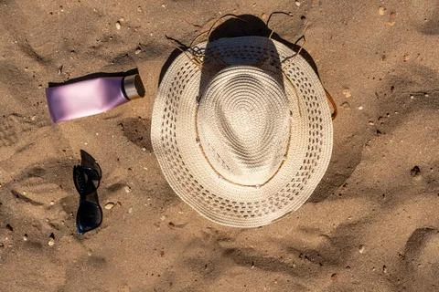 Overhead view of summer beach essentials layout featuring a woven straw hat b Stock Photos