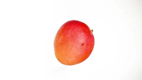 Overhead view of sweet ripe red mango spinning counter clockwise Vídeo Stock 254009746