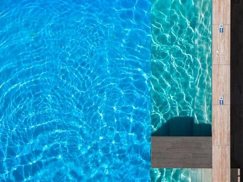 Overhead view of swimming pool steps, deck tiles, and wooden platform Stock Photos