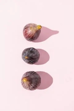 Overhead View of Three Fresh Figs on Light Pink Surface Stock Photos