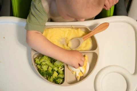 Overhead view of toddler exploring first foods 스톡 사진