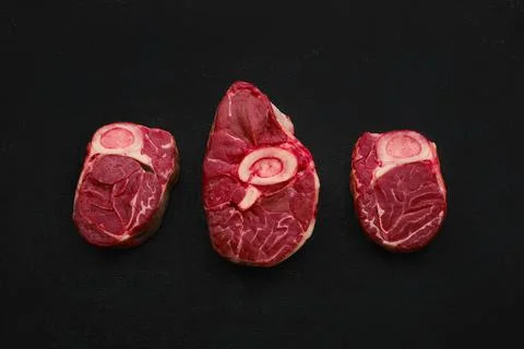Overhead view of tree raw beef shank cross cut, ossobuco on back background Stock Photos