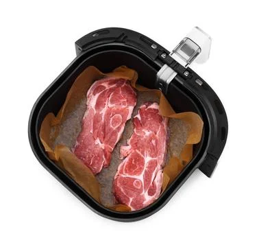 An overhead view of two raw pork neck steaks seasoned and lined with parchm.. Stock Photos