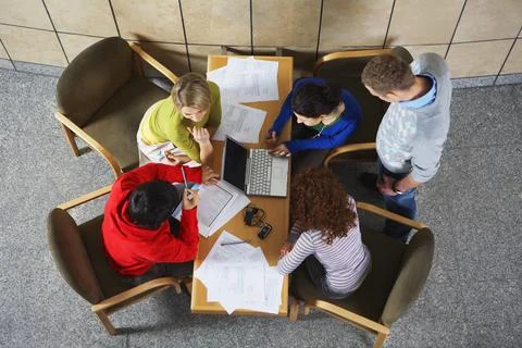 Overhead view of university students using laptop at table Stock Photos