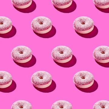 Overhead view of various donuts with confetti arranged on colored background Stock Photos