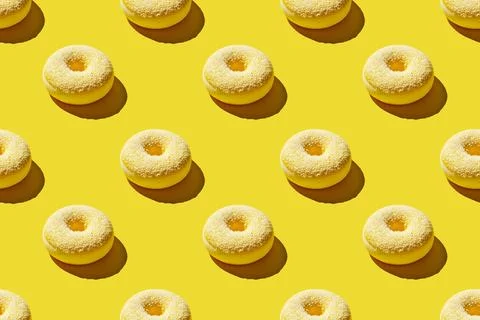 Overhead view of various donuts with confetti arranged on colored background Stock Photos