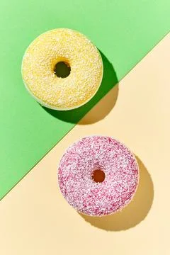 Overhead view of various donuts with confetti arranged on colored background Stock Photos