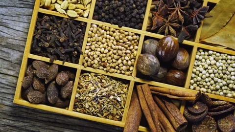 Overhead view of various whole spices in wooden compartments Video stock 333809185