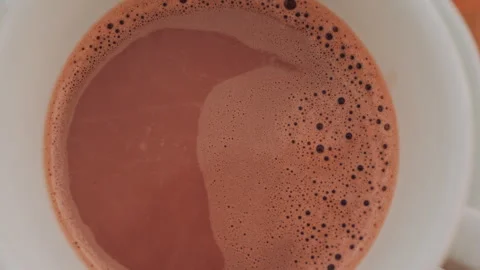Overhead view of a warm cup of hot chocolate or coffee with creamy foam and Stock Footage 322723762