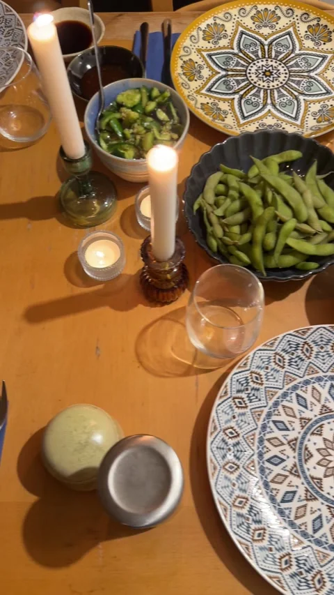 Overhead view of a warmly set dinner table with lit candles, decorative plates Stock Footage 332967487