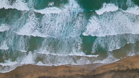 Overhead view of waves splash on desert beach 스톡 동영상 345715962