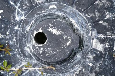 Overhead view of a weathered dark circular object Foto stock