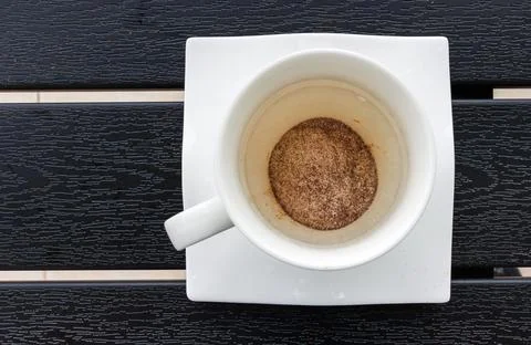 Overhead view of a white cup on a square saucer with instant espresso pulve.. Stock Photos
