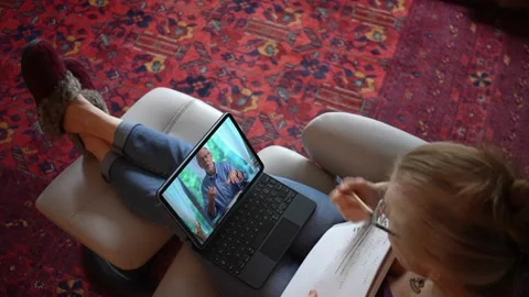 Overhead view of woman with notebook talking to co-worker on tablet computer Stock-Footage 147230703