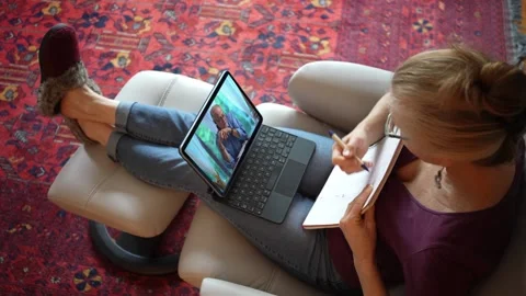 Overhead view of woman with notebook talking to co-worker on tablet computer Stock-Footage 147231010