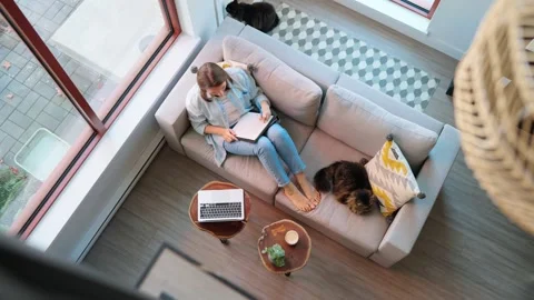 Overhead view of woman writing notes, lying on couch at home Video stock 265202886