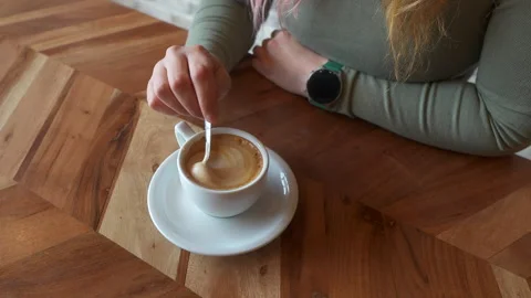 Overhead view of a woman's hand with a coffee cup Stock Footage 264885831