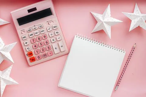 Overhead view working table. on a pink background, a pink calculator, a blank 写真素材