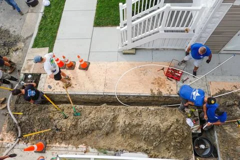 Overhead view of workmen digging a trench to replace a broken pipe in a dri.. Stock Photos