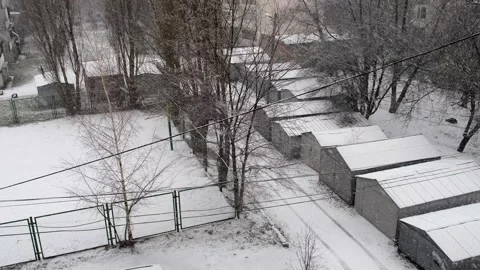 An overhead view of the yard of the car garages with the first white wet Stock-Footage 257427092