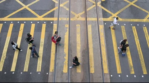 Overhead View of Yellow-Painted Intersection with Pedestrians at Zebra Crossing Stock Footage 294661600